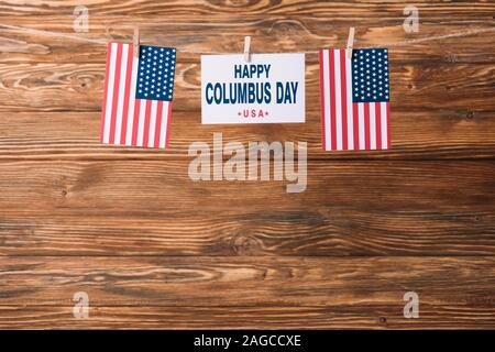 Carte avec happy Columbus day inscription entre drapeaux nationaux d'Amérique sur la surface en bois Banque D'Images