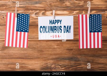 Carte avec happy Columbus day inscription entre american national les drapeaux sur la surface en bois Banque D'Images