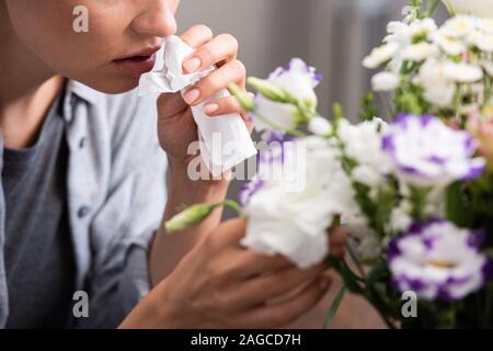 Portrait de femme avec l'allergie au pollen des fleurs et de toucher les tissus holding Banque D'Images