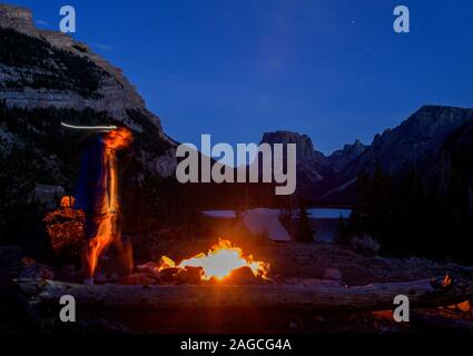 Personne bénéficiant d'un feu tout en camping dans la chaîne Wind River près de Squaretop Mountain, Wyoming. Banque D'Images