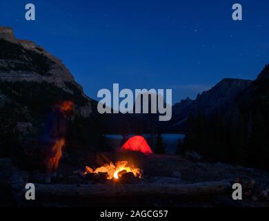 Personne bénéficiant d'un feu tout en camping dans la chaîne Wind River près de Squaretop Mountain, Wyoming. Banque D'Images