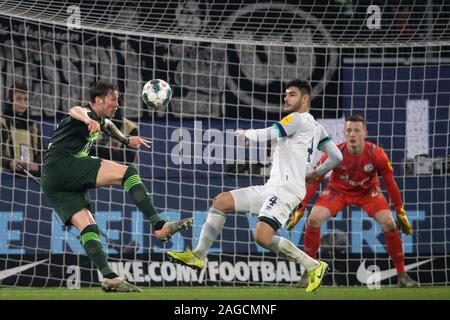 Wolfsburg, Allemagne. Dec 18, 2019. Soccer : Bundesliga, le VfL Wolfsburg - FC Schalke 04, 16e journée à la Volkswagen Arena. Wout Wolfsburgs Weghorst (l) joue contre Schalkes Ozan Kabak et gardien Schalkes Markus Schubert. Credit : Swen Pförtner/DPA - NOTE IMPORTANTE : en conformité avec les exigences de la DFL Deutsche Fußball Liga ou la DFB Deutscher Fußball-Bund, il est interdit d'utiliser ou avoir utilisé des photographies prises dans le stade et/ou la correspondance dans la séquence sous forme d'images et/ou vidéo-comme des séquences de photos./dpa/Alamy Live News Banque D'Images