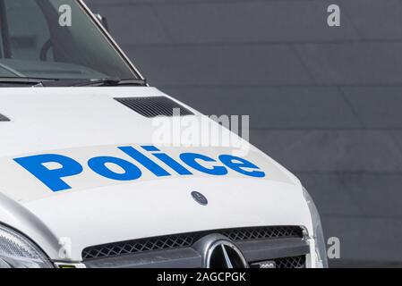 Une vue partielle d'un fourgon de police blanc et le mot écrit en grosses lettres bleues sur le capot avant ou bonnet à Sydney, Australie Banque D'Images