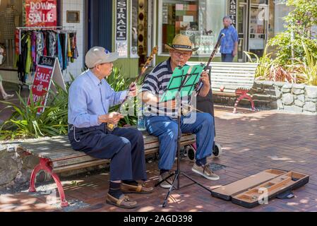 WELLINGTON, Nouvelle-zélande - Jan 27, 2015 : Deux vieux musiciens de rue assis sur un banc dans les rues de Wellington et jouant des instruments Banque D'Images