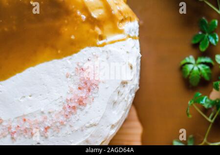 Photo en grand angle d'un délicieux gâteau fraîchement cuit avec glaçage blanc crémeux et sauce caramel Banque D'Images