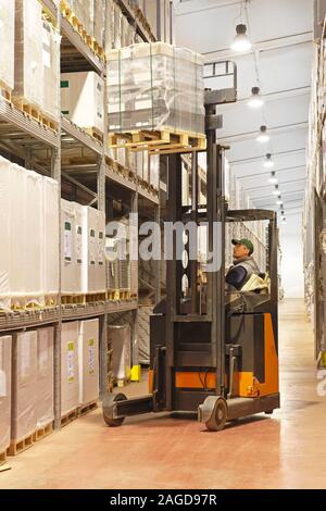 Palettes de chargement avec un chariot élévateur en entrepôt de distribution Banque D'Images