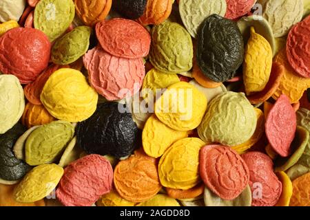 Arrière-plan de l'alimentation - semoule de blé dur coloré non cuit Pâtes Orecchiette avec l'ajout de la ingrédients spéciaux : carotte, betterave rouge, spina Banque D'Images