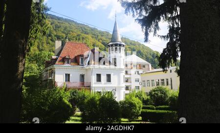 Manoir avec murs blancs et toit rouge Un jardin entouré de collines et de forêts en Roumanie Banque D'Images