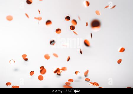 Confettis tombant en or rose sur fond blanc. Maison de concept. Banque D'Images