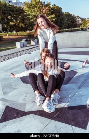 3 copines filles adolescents 12 à 15 ans, Ride skateboard, 24 rue de ville, sourire heureux profiter s'amuser après l'école au collège. Relaxation émotions Banque D'Images