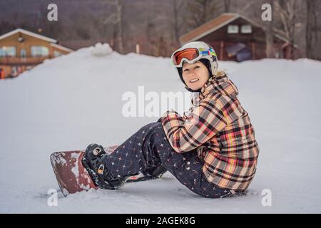 Femme snowboarder sur un jour d'hiver ensoleillé dans une station de ski Banque D'Images