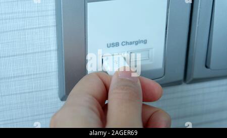 Part en branchant un câble USB dans un port de charge USB. Banque D'Images