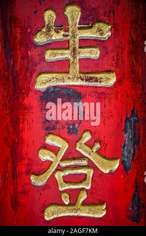 Golden l'écriture chinoise caractères sur un mur rouge dans le monastère de Wenshu, Chengdu, province du Sichuan, Chine Banque D'Images