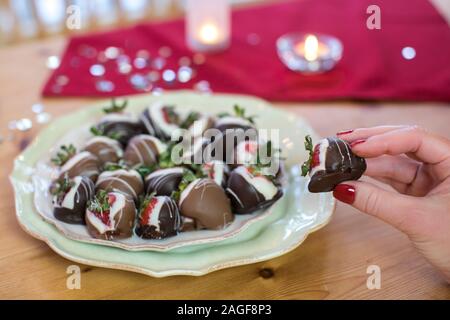 Woman's hand holding-chocolat fraises trempées Banque D'Images