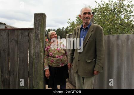 Ivan Ilchenko avec sa femme Maria en face de leur ferme dans le village Kupovate, situé dans la zone d'exclusion de Tchernobyl. Les deux sont des résidents illégaux (Samosely), qui revint quelques mois après l'évacuation de la zone d'exclusion de Tchernobyl (à la suite de la catastrophe de Tchernobyl en avril 1986) à leur ferme. Kupovate, zone d'exclusion de Tchernobyl, Ivankiv, Kiev Kiev oblast, Ukraine, Europe de l'Est Banque D'Images