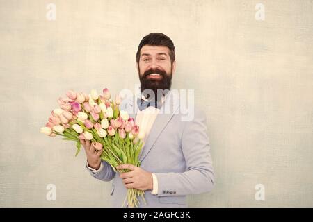 Tulipes pour ma chérie. Homme très soigné porter Bow-tie tuxedo tenir fleurs bouquet. Inviter ses sorties. Homme romantique avec des fleurs. Cadeau romantique. Macho prêt date romantique. En attente de Darling. Banque D'Images