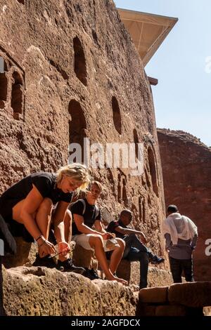 L'Éthiopie, région d'Amhara, Lalibela, touristes mettre chaussures sur après avoir visité l'église de roche Banque D'Images