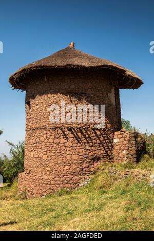 L'Éthiopie, région d'Amhara, Lalibela, ville historique, maison en pierre circulaire traditionnel en chaume, habitants déplacé hors de tidy, zone d'équipement pour les touristes Banque D'Images