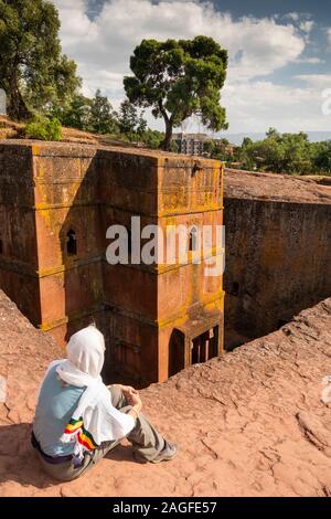 L'Éthiopie, région d'Amhara, Lalibela, senior woman avec tête couverte au-dessus de Bet Giyorgis, St George's Lailibela rock découvert seulement l'église de coupe Banque D'Images