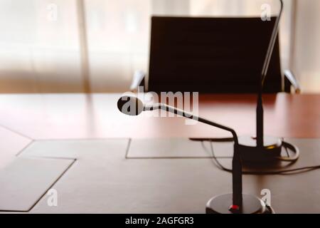 Un microphone sur une table en bois et une chaise vide dans une salle de réunion. Concept d'affaires Banque D'Images