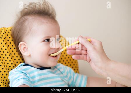 Manger une cuillère de bébé mange de la bouillie de lait Banque D'Images