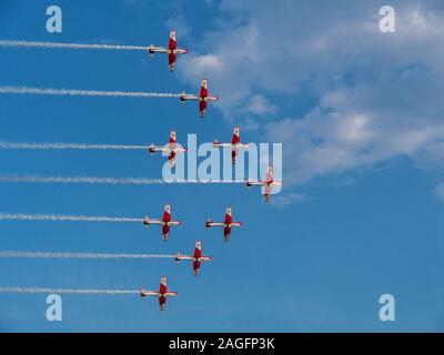 Jets rouges effectuant un spectacle aérien tout en laissant des pistes blanches dedans le ciel Banque D'Images