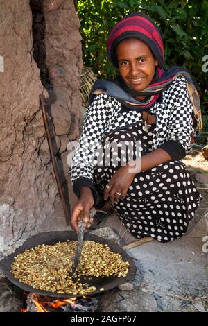 L'Éthiopie, région d'Amhara, Lalibela, ville historique, femme de la torréfaction des grains de café frais pour faire buna Banque D'Images