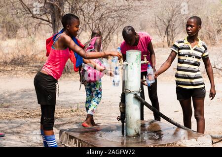 Sites d'art rupestre des collines de Tsodilo, étudiants locaux en visite, puits d'eau sur le site du camp, dans le désert de kalahari, Botswana, Afrique australe, Afrique Banque D'Images