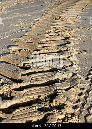 Les pistes dans le sable - Traces de pneu laissées par un tracteur de pêcheur sur une plage à Norfolk. Banque D'Images