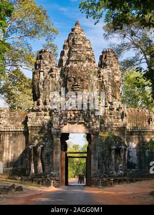 Un tuc-tuc passe sous la majestueuse porte de la victoire d'Angkor Thom près de Siem Reap au Cambodge. Banque D'Images