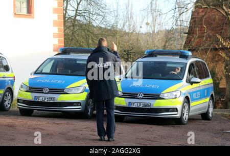 19 décembre 2019, la Thuringe, Großkochberg : un agent de police demande à un nouvelle radio voiture de patrouille pour la police de Thuringe avant un transfert symbolique dans la cour du château Großkochberg. Trois véhicules de chaque modèle sera présenté lors de l'événement. Ce sont 54 VW Touran, VW Tiguan, 37 14 VW T6 et 11 l'Audi A6. Photo : Bodo/Schackow Zentralbild-dpa/ZB Banque D'Images