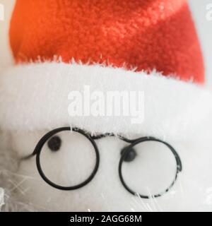 Résumé de jouets en face du Père Noël en noir lunettes rondes et red hat, gros plan les yeux. Banque D'Images