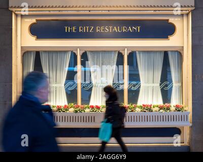 Les gens en passant devant la fenêtre du Ritz Restaurant Londres Royaume-uni, avec fenêtre et signe avec des fleurs dans une fenêtre de dialogue à l'extérieur. Banque D'Images