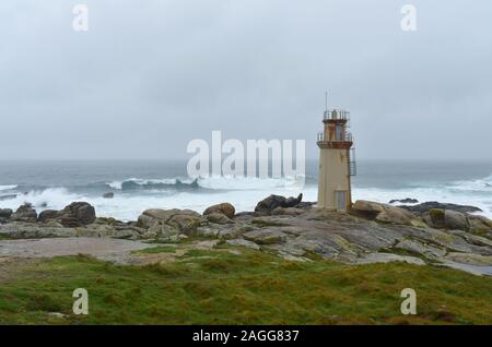 Célèbre phare situé à Muxia au pèlerinage de Saint-Jacques avec tempête et des vagues. L'Espagne. Banque D'Images