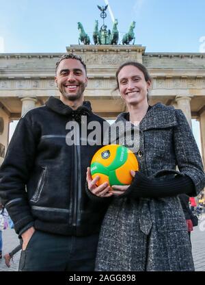 19 décembre 2019, Berlin : volley-ball : conférence de presse de l'Association Volley CEV à l'hôtel Adlon avec des représentants de la VBL, DVV, BR de volée et l'Administration du Sénat de l'Intérieur et du Sport. Benjamin Patch (l), DVD BR de volée, et Christiane Fürst, trois fois vainqueur de la Ligue des Champions, sont debout devant la porte de Brandebourg avec volley boules. L'Association de volley-ball (CEV), l'Association de volley-ball allemand (DVV), le volley-ball Football (VBL), la ville de Berlin Berlin et le recyclage de volée poursuivront leur étroite coopération en 2020. Ph Banque D'Images