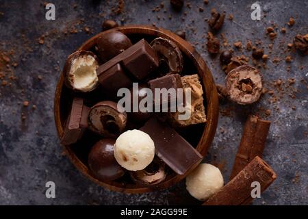 Brisures de chocolat noir et blanc. Morceaux de chocolats sur une table en pierre grise Banque D'Images