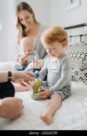 Couple et enfants jouant dans le lit Banque D'Images