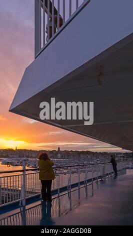 Les visiteurs sur des ferry arrivant à Saint Malo avec yachts bateaux amarrés dans la marina au lever du soleil à Saint-Malo, Bretagne, France en Décembre Banque D'Images