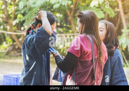 LAMPHUN THAÏLANDE - 8 décembre : Unidentified woman aide sa mère pour attacher un foulard sur Décembre 8,2019 à Karen village de Lamphun, Thaïlande. Banque D'Images