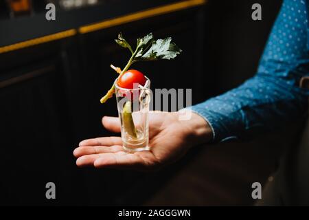 Le serveur est titulaire d'une vitre sale de sous le verre sur sa paume. Banque D'Images