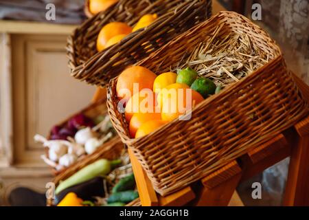 Panier en osier avec fruits frais et aromatiques. Au fond du panier se trouve la paille et la feuille de laurier. Paniers de fruits de se tenir dans une ligne. Banque D'Images