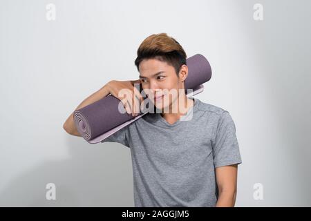 Man holding rolled up Fitness exercise mat Banque D'Images