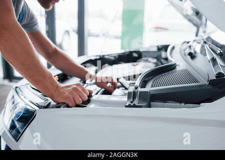 Processus de réparation après accident de voiture. L'homme travaillant avec le moteur sous le capot Banque D'Images