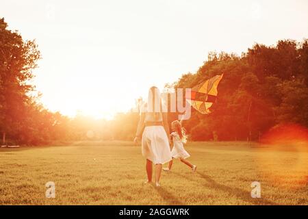 Des couleurs vives. Mère et fille s'amuser avec le kite dans le domaine. La belle nature Banque D'Images