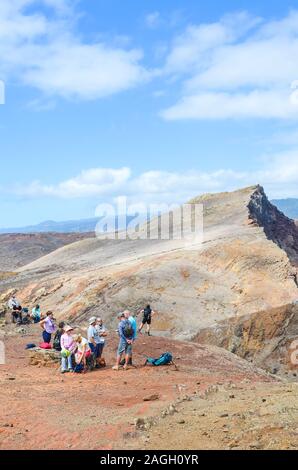 La Ponta de Sao Lourenço, Madeira, Portugal - Sep 12, 2019 : groupe de touristes ayant un reste sur les falaises dans le point le plus à l'Est de l'île de Madère. Paysage volcanique en arrière-plan. Photo verticale. Banque D'Images