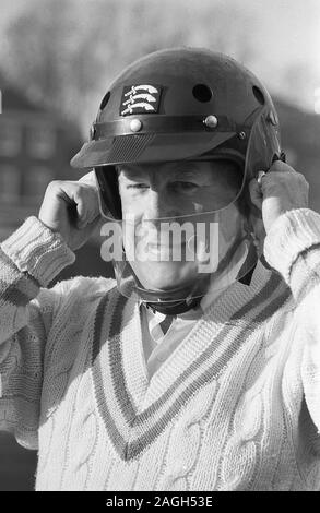 1980, cricketer essayant sur un nouveau casque de cricket avec un guide de sécurité en plastique, Angleterre, Royaume-Uni. Les chapeaux de protection du cricket n'étaient pas utilisés en commun avant la fin des années 1970 et évoluaient à mesure que le batteur cherchait à se protéger de la tête par un court bowling rapide. En 1978, Graham Yallop, d'Australie, est devenu le premier cricketeur à porter un dans un match d'essai. Banque D'Images