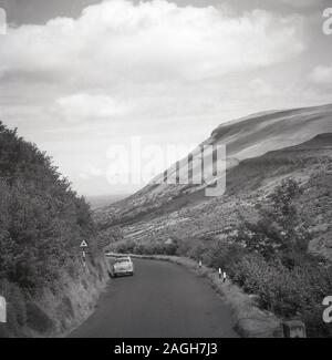 Années 1950, historiques, une automobile de l'époque stationné dans une route de campagne dans les montagnes de la Co. d'Antrim, en Irlande du Nord. Banque D'Images