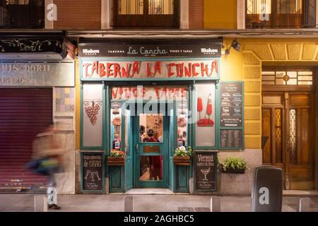 Une personne est pris comme un flou comme la marche passé Taberna La Concha sur Calle de la Cava Baja, Madrid, Espagne la nuit. Banque D'Images