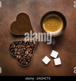 Les grains de café torréfié et de masse, et d'un espresso avec une vue de dessus sur un fond brun Banque D'Images