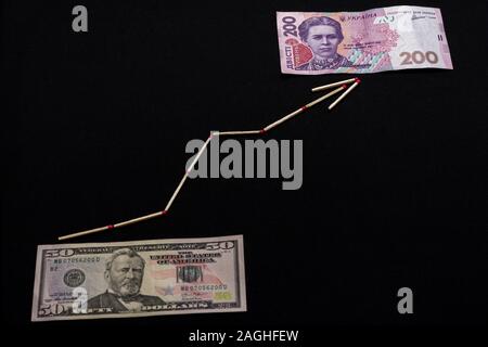 Hryvnia ukrainien et US dollar avec la flèche sur fond noir. Banque D'Images